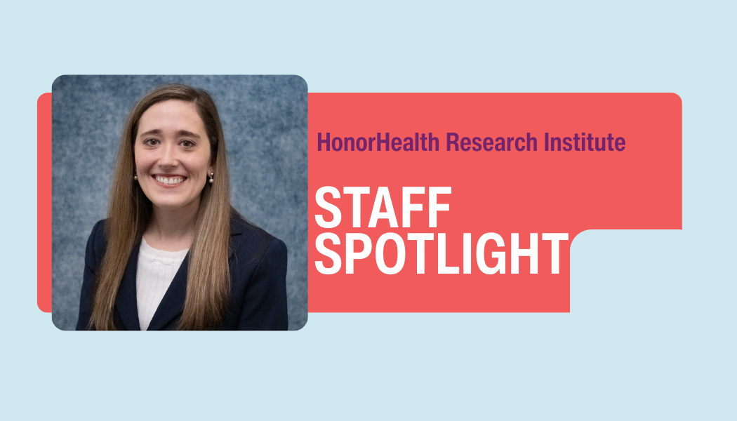 A woman with long brown hair in a suit smiles at the camera next to a graphic that reads “HonorHealth Research Institute Staff Spotlight.”.